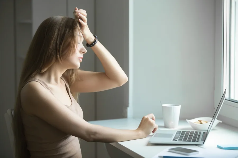 Mulher em frente ao computador cansada